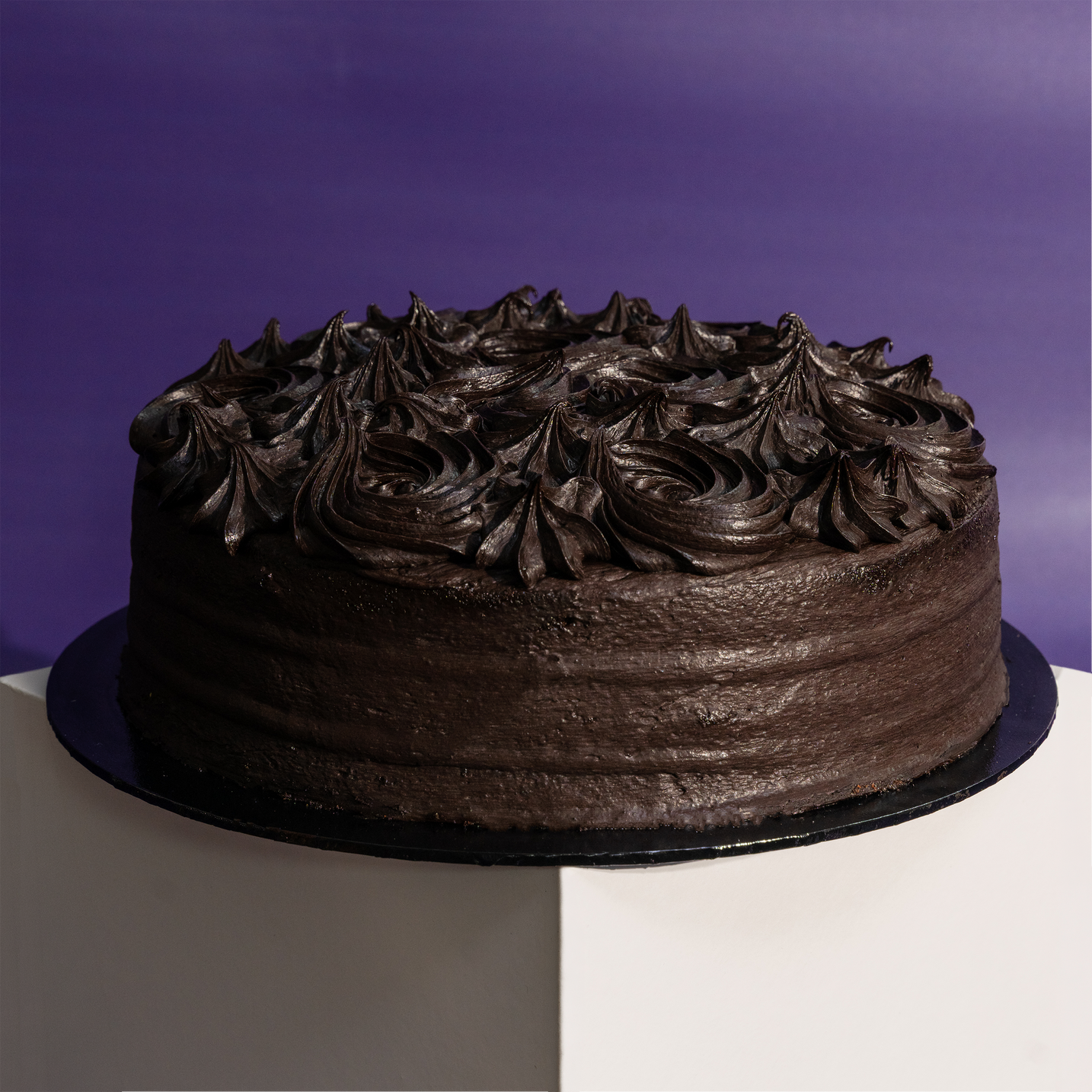 Whole round dark chocolate cake finished with piped rosettes — Elevete Patisserie KL
