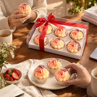 Blush Rosette cupcakes on a plate at a table set for tea, with the ribboned gift box behind