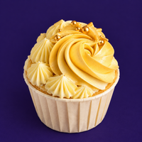 Sunny Swirl vanilla cupcake piped in gold, with pale yellow stars and gold sugar pearls