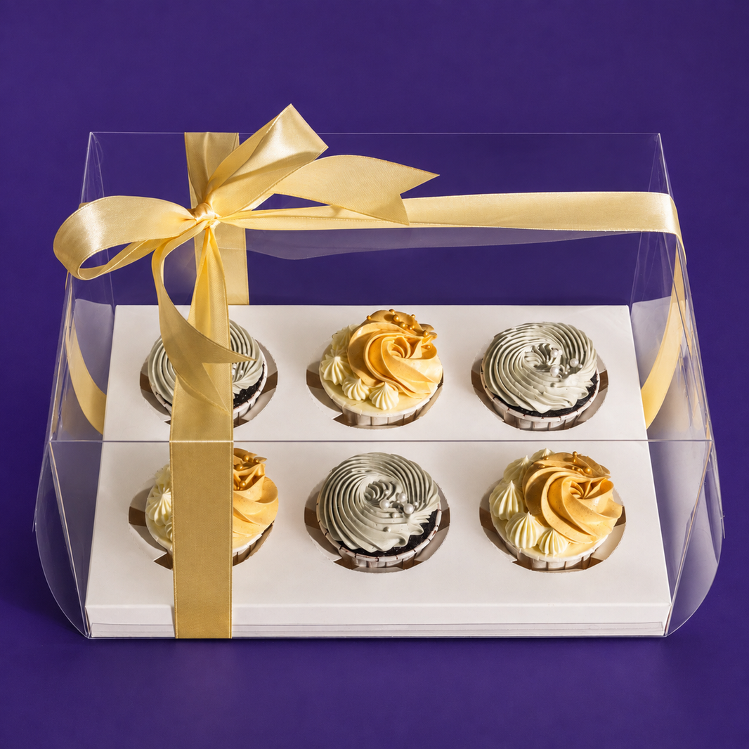 Sunny Swirl cupcake gift box: three gold and three pale sage cupcakes in a clear box tied with a gold ribbon