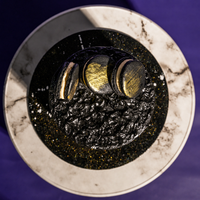 Top-down view of the Midnight Gold designer cake and its ring of dark macarons