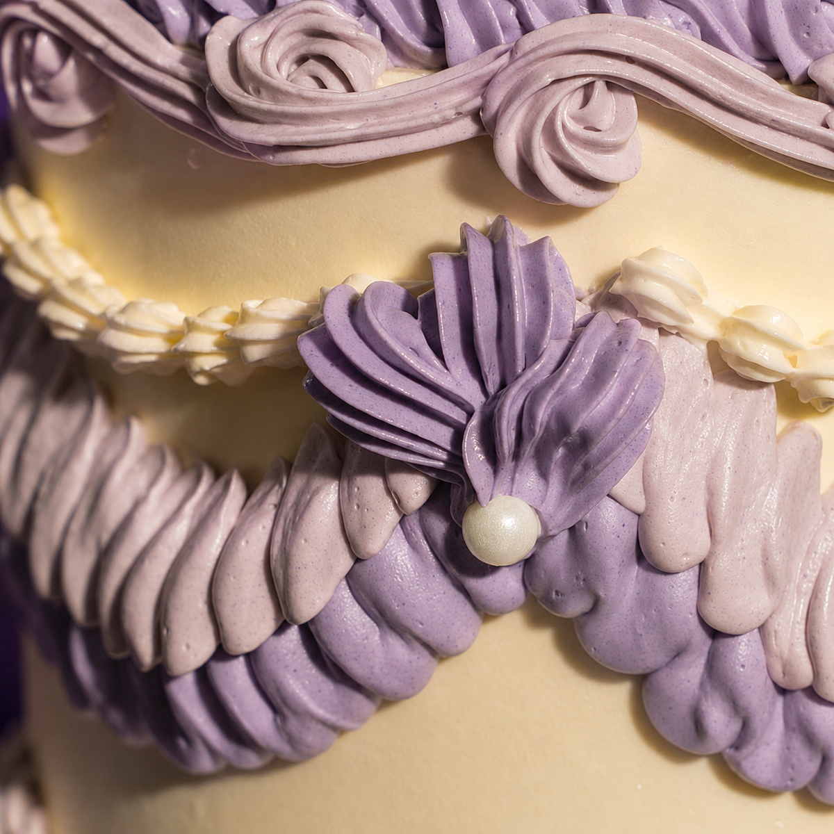 Close-up of lilac piped swags and a sugar pearl on the Vintage Bloom cake