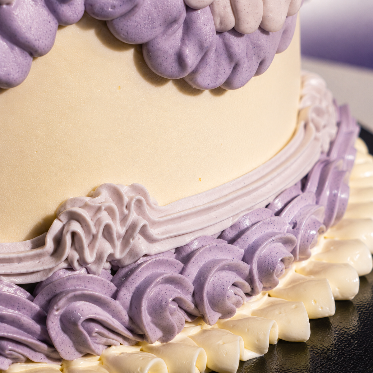 Rope and shell piping around the base of the Vintage Bloom designer cake in lilac