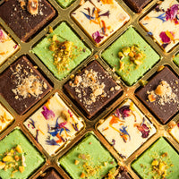 Close-up of pistachio, chocolate and milk burfi squares in a gold tray