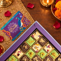 Top-down corner of a burfi gift box showing milk, pistachio and chocolate squares