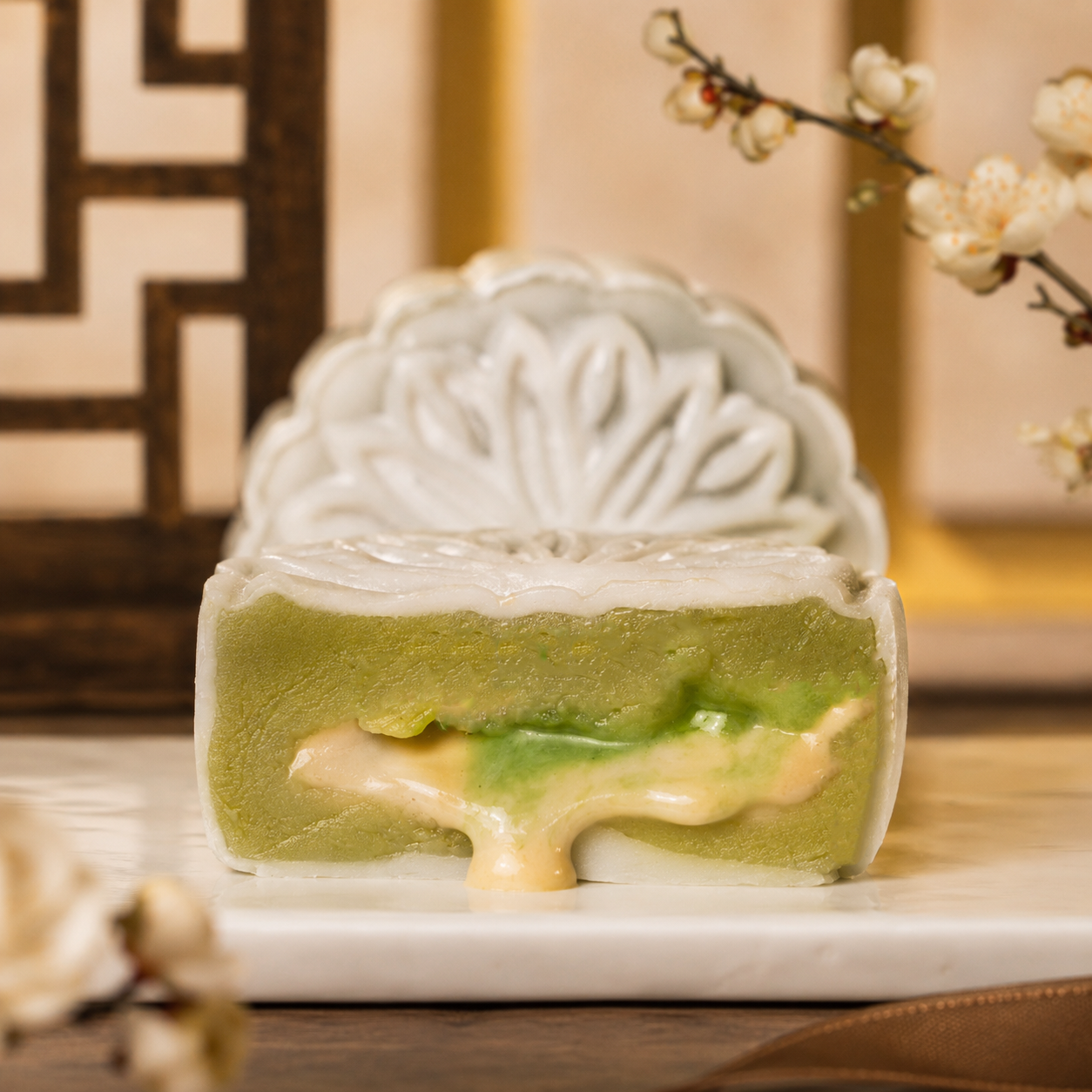 Matcha red bean snowskin mooncake cut open with matcha lava and black sesame