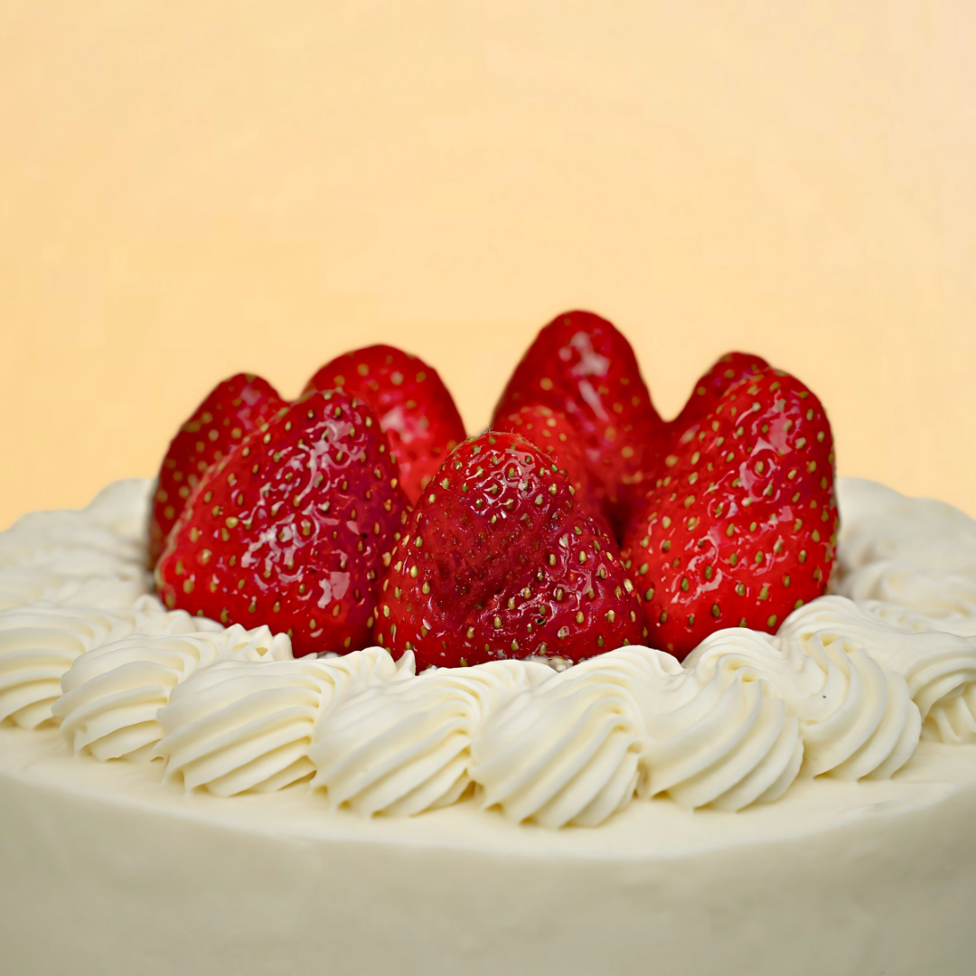 Cake with whipped cream and strawberries on a yellow background