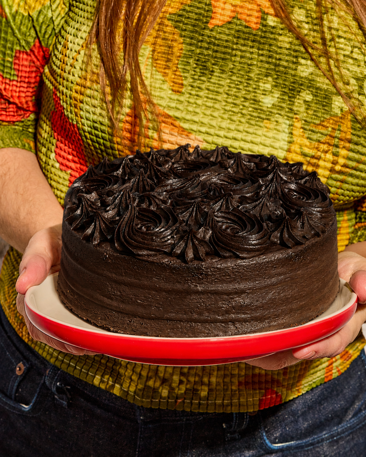 Person holding a whole Elevete Patisserie Ultimate Chocolate Cake halal certified, same-day delivery across Kuala Lumpur & Selangor