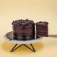 Serving a slice of Mini Death by Chocolate Cake decorated with generous amount of Chocolate Ganache Rosettes On Top by Elevete Patisserie