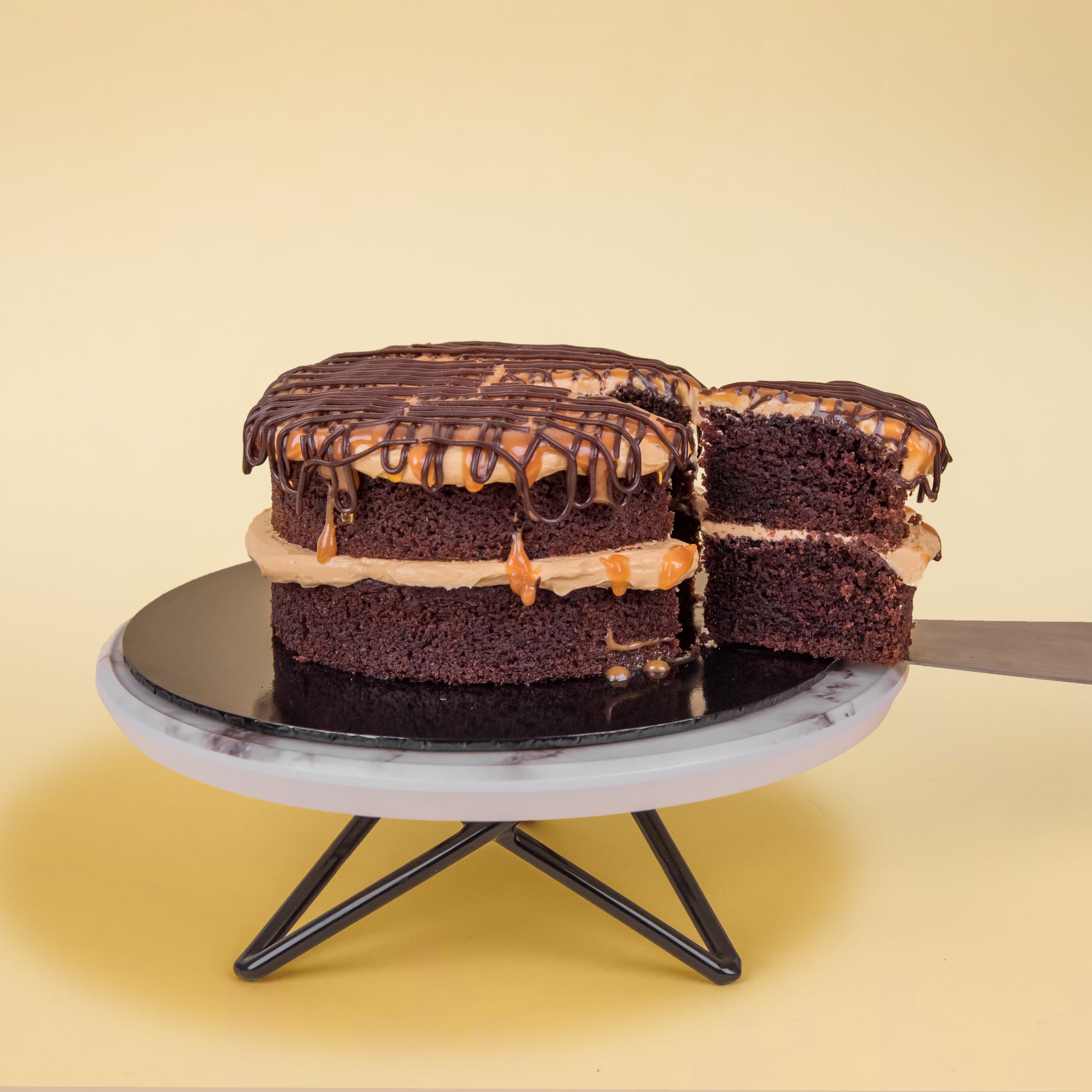 Serving a slice of Mini Salted Caramel Chocolate Cake with Chocolate & Salted Caramel Drizzle On Top by Elevete Patisserie
